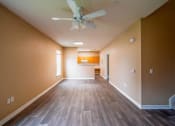 Thumbnail 43 of 69 - a empty living room with a ceiling fan and wood floors
