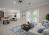 Thumbnail 13 of 50 - A living room with a beige couch, a wooden coffee table, and a ceiling fan.