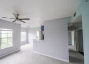 Thumbnail 25 of 31 - a living room with a ceiling fan and a large window