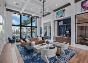 Thumbnail 5 of 78 - a living room with large windows and a couch and chairs at Altis Blue Lake, Lake Worth, FL, 33467