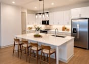 Thumbnail 36 of 40 - A modern kitchen with white cabinets and a large island.