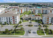 Thumbnail 27 of 27 - A large apartment complex with a roundabout in the middle of the parking lot.