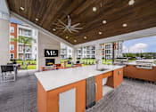 Thumbnail 14 of 27 - A modern outdoor kitchen with a grill and sink.