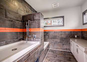 Thumbnail 21 of 27 - A bathroom with a white tub and a shower with a glass door.