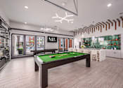Thumbnail 24 of 27 - A billiard table is in the middle of a room with a pool table light.