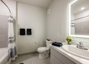 Thumbnail 10 of 27 - A bathroom with a toilet, sink, and shower.