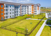 Thumbnail 15 of 23 - Pet-Friendly Apartments In Daytona Beach - Madison Pointe - Fenced Dog Park With Lush Grass, Agility Equipment, And Shaded Seating Benches.