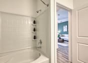 Thumbnail 26 of 49 - A white bathroom with a white tub and a white door.