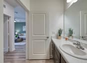 Thumbnail 24 of 49 - A bathroom with a white sink and a white door.