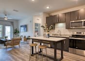 Thumbnail 28 of 49 - A modern kitchen with dark wood cabinets and stainless steel appliances.