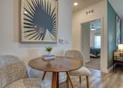 Thumbnail 32 of 49 - A modern dining room with a round wooden table and two chairs.