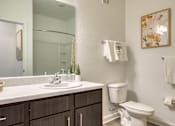 Thumbnail 38 of 49 - A bathroom with a white toilet and a mirror above the sink.