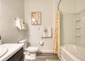 Thumbnail 39 of 49 - A bathroom with a toilet, sink, and a shower curtain.