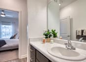 Thumbnail 34 of 49 - A bathroom with a marble countertop and a large mirror.