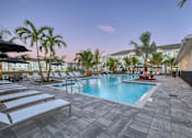 Thumbnail 2 of 49 - A pool surrounded by palm trees and lounge chairs.