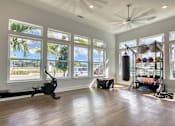 Thumbnail 15 of 49 - A spacious room with a treadmill, a punching bag, and a rack of exercise equipment.