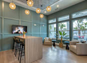 Thumbnail 7 of 49 - A modern living room with a bar area and a flat screen TV.