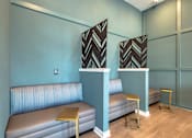 Thumbnail 12 of 49 - A room with two grey couches and two tables with a black and white patterned tablecloth on top.