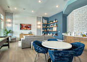 Thumbnail 9 of 49 - A modern living room with a dining table and blue chairs.