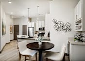 Thumbnail 23 of 34 - A modern kitchen with a dining table and chairs.