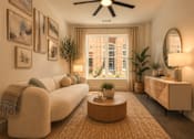 Thumbnail 5 of 33 - A living room with a white sofa, a round coffee table, and a ceiling fan.