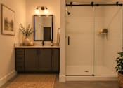 Thumbnail 7 of 33 - A bathroom with a white shower and a mirror above a cabinet.