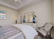 Thumbnail 28 of 53 - A bedroom with a large bed and a chair.