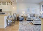 Thumbnail 24 of 53 - A living room with a grey couch and a white coffee table.