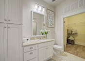 Thumbnail 30 of 53 - A bathroom with a white vanity and a white toilet.