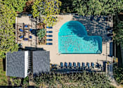 Thumbnail 9 of 30 - A heart-shaped pool surrounded by lounge chairs and trees.