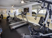 Thumbnail 28 of 30 - A gym with treadmills, elliptical machines, and other exercise equipment.