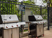 Thumbnail 13 of 28 - Two grills are placed next to a fence.