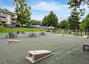 Thumbnail 18 of 28 - A park with a basketball court, picnic tables, and umbrellas.