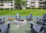 Thumbnail 19 of 28 - A fire pit surrounded by chairs in a backyard.