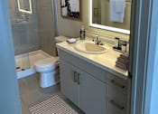 Thumbnail 14 of 27 - A bathroom with a toilet, sink, and mirror.