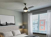 Thumbnail 11 of 27 - A bedroom with a large bed and a painting of a bridge on the wall.