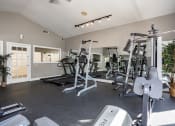 Thumbnail 32 of 44 - a gym with cardio machines and weights on the floor
