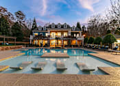 Thumbnail 1 of 38 - A large house with a pool in front of it.