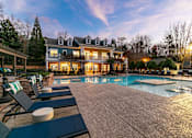 Thumbnail 31 of 38 - A large house with a pool in front of it.