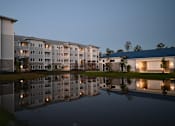 Thumbnail 1 of 31 - Apartment buildings are reflected in the water in front of them.