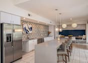 Thumbnail 11 of 42 - A modern kitchen with a large island and stainless steel appliances.