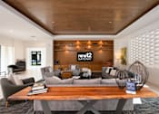 Thumbnail 4 of 42 - A modern living room with a wooden ceiling and a coffee table in the center.