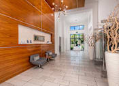 Thumbnail 3 of 42 - A hallway with a wooden wall and a white vase.