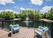 Thumbnail 38 of 42 - Two chairs on a deck overlooking a lake.