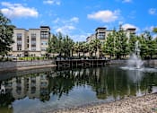 Thumbnail 40 of 42 - A fountain in the middle of a pond in front of a building.