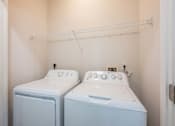 Thumbnail 26 of 42 - A small laundry room with a washer and dryer.