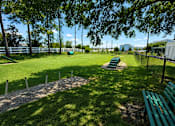 Thumbnail 24 of 31 - A green park with a bench and a fence.
