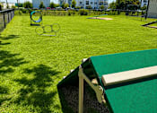 Thumbnail 25 of 31 - A playground with a green slide and a green and white slide.