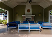 Thumbnail 18 of 31 - A patio with a fireplace and blue couches.