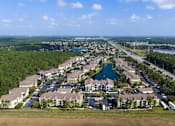 Thumbnail 27 of 31 - A bird's eye view of a residential area with houses and a lake.